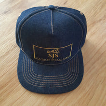 Load image into Gallery viewer, Photo from above Full denim truckers cap with gold SJS &quot;planer&quot; logo on front panel
